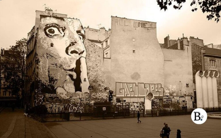 Graffiti géant à Paris représentant un visage de femme faisant le geste du silence sur un mur urbain