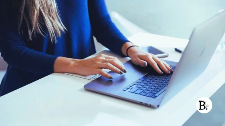 Femme blonde copywriter tapant sur le clavier d'un macbook apple
