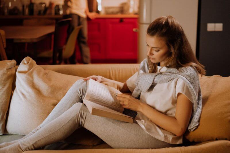 Lectrice assise sur son canapé avec un livre dans les mains Portrait de lecteur : Lundi Soleil met la lecture en lumière