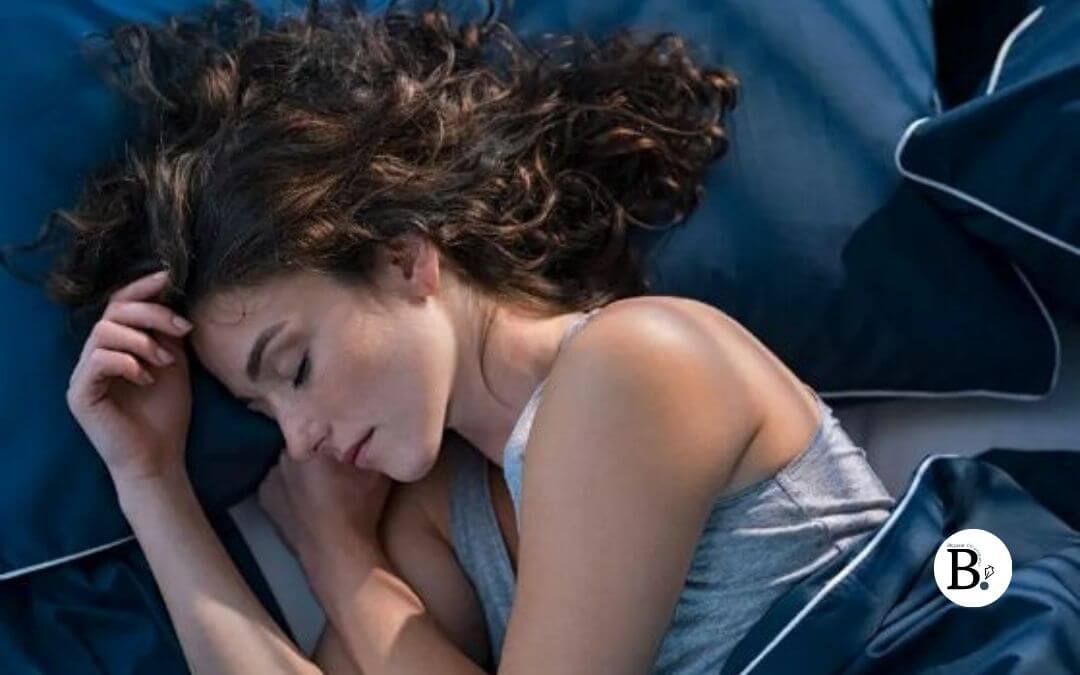 Femme aux cheveux longs qui dort sur le côté avec un sentiment de bonheur