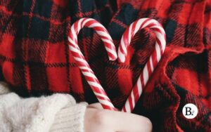 Deux sucres d'orge rouge et blanc tenus dans une main