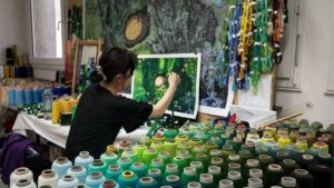 Aiko Konomi travaillant les chapelets de couleurs pour la tapisserie La sieste de Mei et Totoro - Cité internationale de la tapisserie ©Zoé Forget