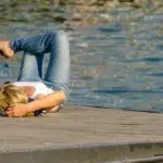 femme blonde allongée sur le dos qui lit un livre