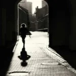 Photo en noir et blanc d'une femme qui avance dans une ruelle à contre-jour