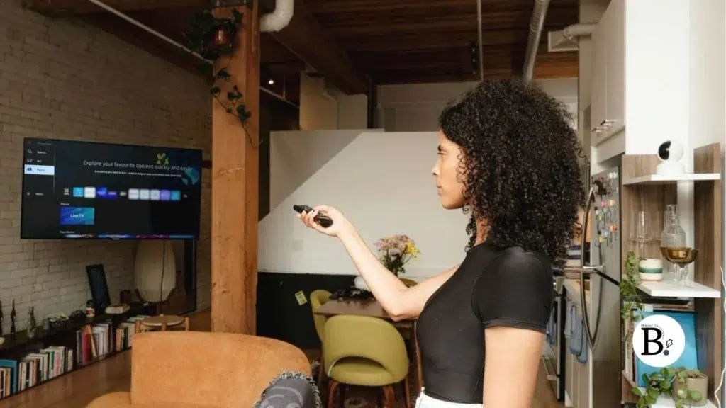femme cheveux frisés télécommande smartv IPTV France : les avantages de la télévision par Internet