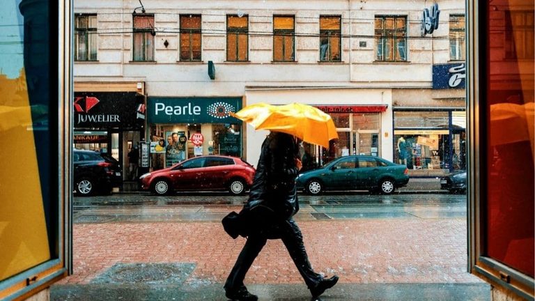 Personne emmitouflée marchant sous la pluie