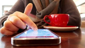 Main touchant l'écran d'un smartphone