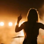 Silhouette d'une femme de dos levant les bras