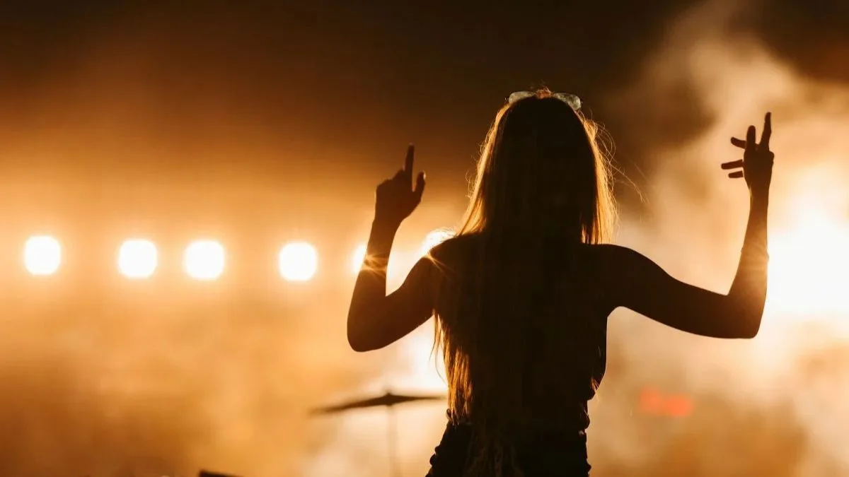 Silhouette d'une femme de dos levant les bras